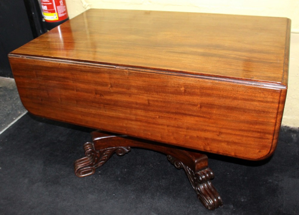 A polished mahogany William IV drop-leaf centre table featuring a rectangular top, drop sides, and a carved pedestal base with scroll feet. View II