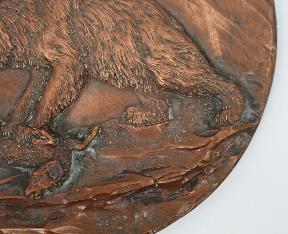 A circular antique copper relief plaque depicting a bear with prey in a rocky forest setting under an oak branch. View IV