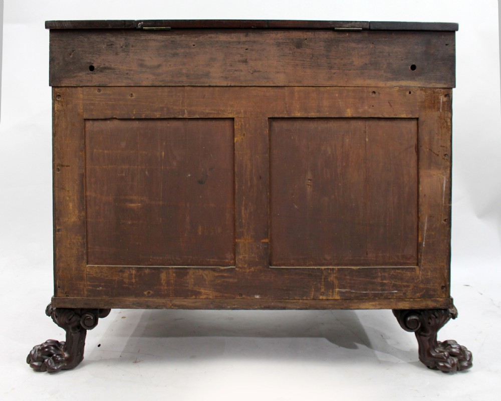 Late 18th-century mahogany kneehole desk featuring carved lion paw feet, brass ring drawer handles, and a central cupboard door decorated with a carved laurel wreath. View XV