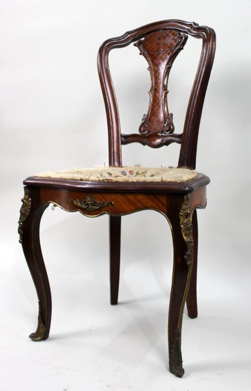 fig 1. An antique French side chair featuring a kingwood back frame with a parquetry splat, cabriole front legs decorated with ormolu mounts, and a floral needlepoint seat.