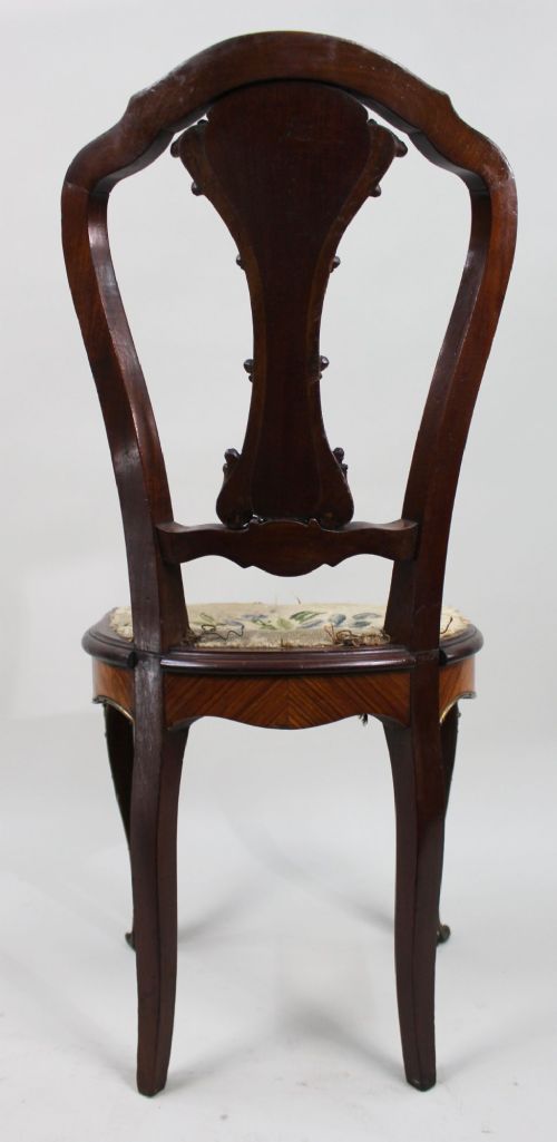 An antique French side chair featuring a kingwood back frame with a parquetry splat, cabriole front legs decorated with ormolu mounts, and a floral needlepoint seat. View VIII