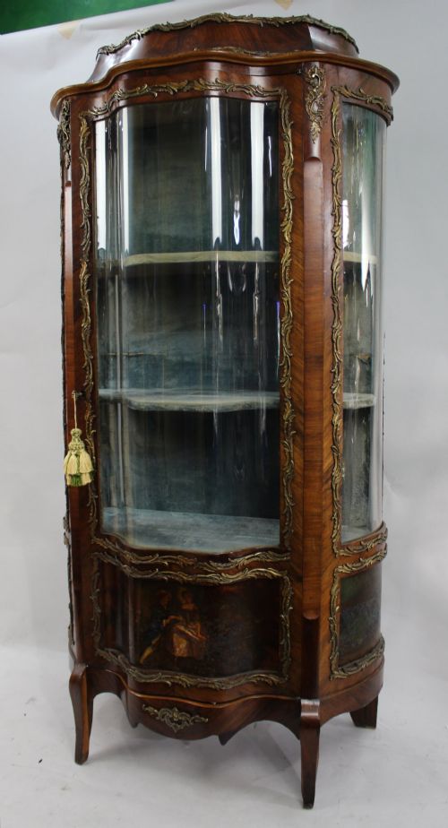 fig 1. A nineteenth-century French serpentine display cabinet featuring curved glass panels, gilt bronze mounts, and hand-painted Vernis Martin panels on the lower section.