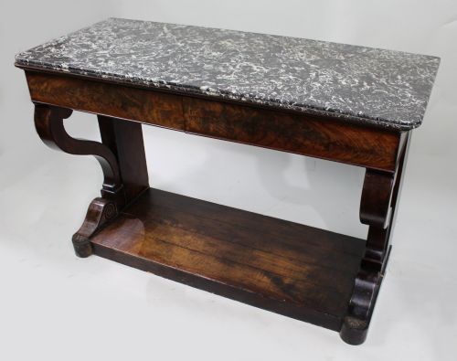 fig 1. An antique dark mahogany French console table featuring a grey and white mottled marble top, curved scroll legs, and a low plinth shelf.