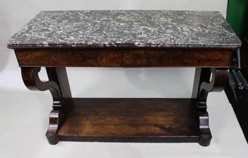 fig 3. An antique dark mahogany French console table featuring a grey and white mottled marble top, curved scroll legs, and a low plinth shelf.