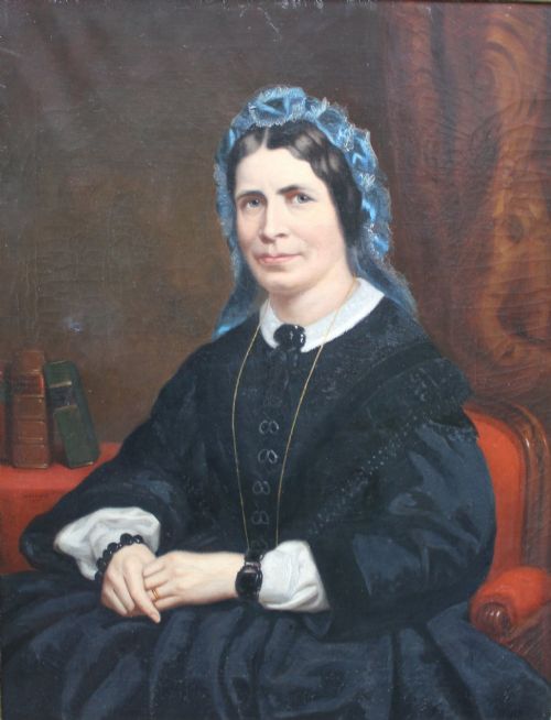 fig 1. A 19th-century oil painting depicting a seated woman in a dark gown and blue lace bonnet, set within an ornate gold gilt frame.