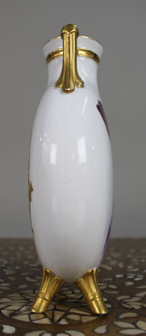 A white porcelain moon flask vase with twin gilded handles, four scroll feet, and a hand-painted portrait of a woman in a purple hat signed Baston. View V