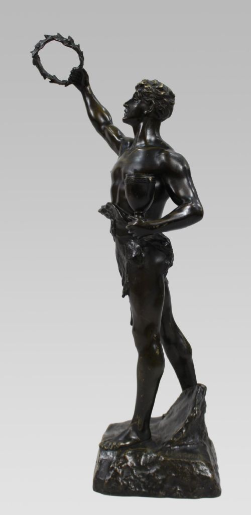 A dark patinated bronze figure of a classical male holding a raised wreath in one hand and a vessel in the other. View VIII