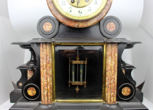 fig 2. A 19th-century French black slate and red variegated marble clock garniture set with a central architectural clock and flanking side tazzas.