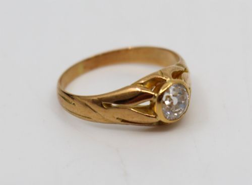 fig 1. An antique rose gold ring featuring a central round old-cut diamond set within carved shoulders.