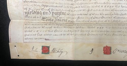 fig 3. An 1782 handwritten George III vellum tripartite legal indenture featuring ornate calligraphy, a blue revenue stamp, and three red wax seals along the bottom edge.