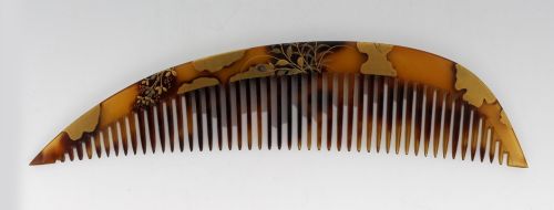 fig 1. A two-piece Japanese hair ornament set comprising a crescent comb and a slender pin, crafted from mottled amber tortoiseshell with gold lacquer botanical motifs.