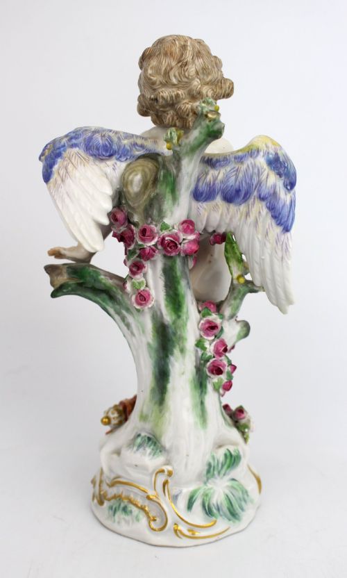 fig 3. A Meissen hard-paste porcelain figurine depicting a winged cupid bound with a pink rose garland, standing on a gilded scrollwork base.