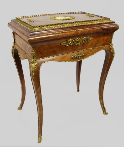 fig 1. A 19th-century French kingwood jardiniere table featuring geometric parquetry inlay, ornate gilt-bronze mounts, cabriole legs, and a central floral porcelain plaque.