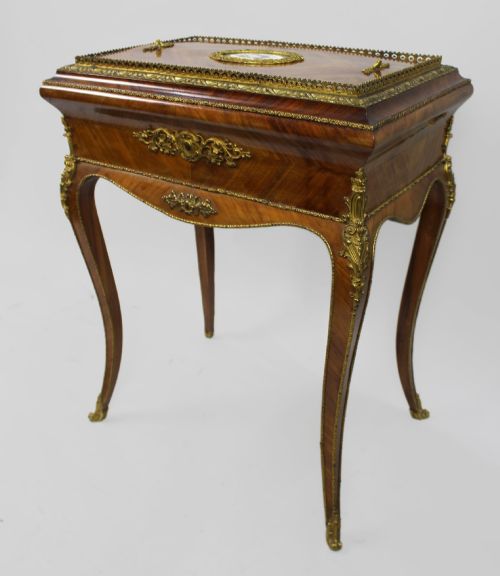 fig 2. A 19th-century French kingwood jardiniere table featuring geometric parquetry inlay, ornate gilt-bronze mounts, cabriole legs, and a central floral porcelain plaque.