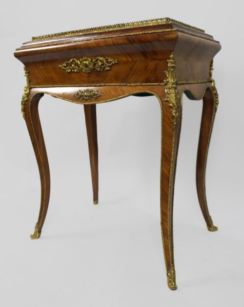 fig 3. A 19th-century French kingwood jardiniere table featuring geometric parquetry inlay, ornate gilt-bronze mounts, cabriole legs, and a central floral porcelain plaque.