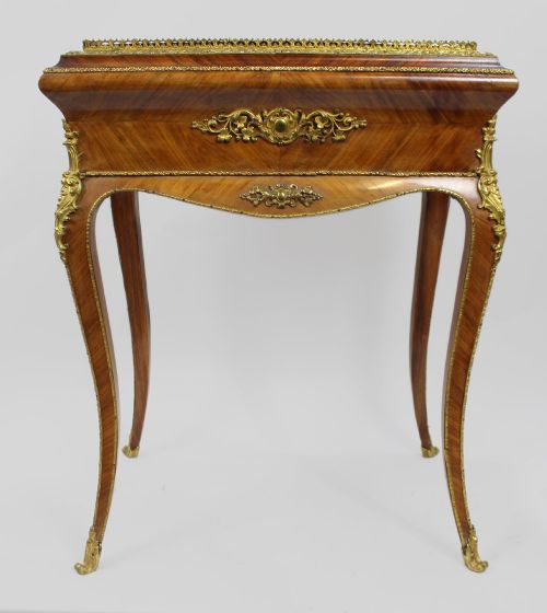 fig 4. A 19th-century French kingwood jardiniere table featuring geometric parquetry inlay, ornate gilt-bronze mounts, cabriole legs, and a central floral porcelain plaque.