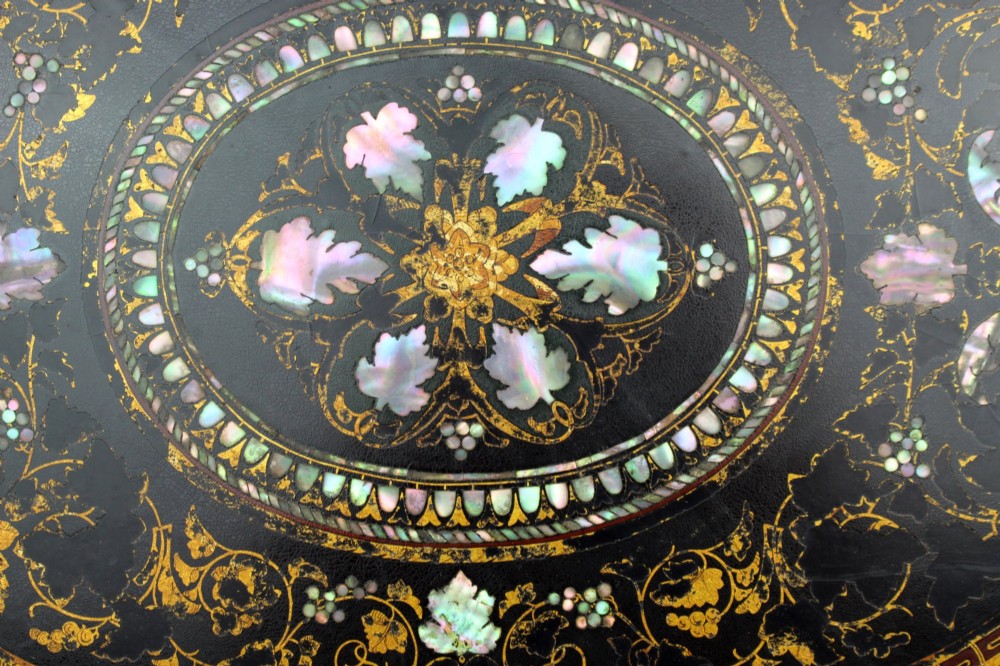 An oval Victorian black lacquered papier-mache tray featuring ornate gilt floral scrolls and iridescent mother-of-pearl leaf inlays around a central medallion. View III