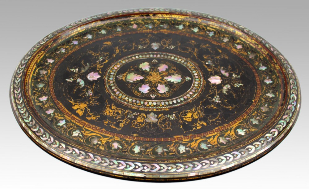 An oval Victorian black lacquered papier-mache tray featuring ornate gilt floral scrolls and iridescent mother-of-pearl leaf inlays around a central medallion. View V