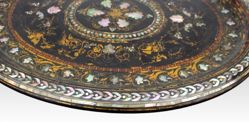 An oval Victorian black lacquered papier-mache tray featuring ornate gilt floral scrolls and iridescent mother-of-pearl leaf inlays around a central medallion. View VII