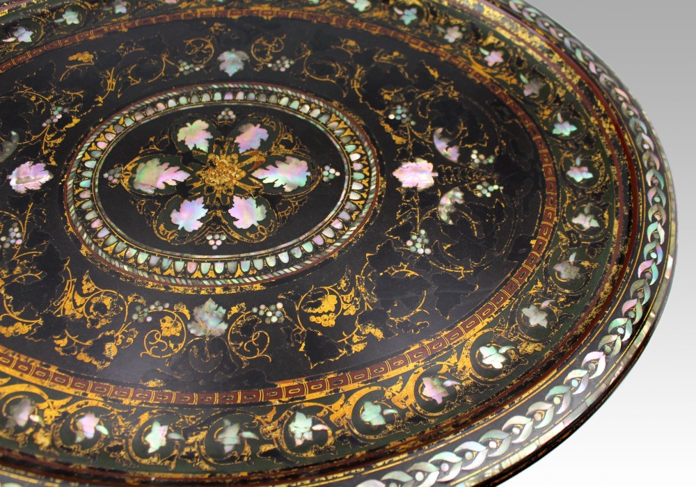 An oval Victorian black lacquered papier-mache tray featuring ornate gilt floral scrolls and iridescent mother-of-pearl leaf inlays around a central medallion. View VIII