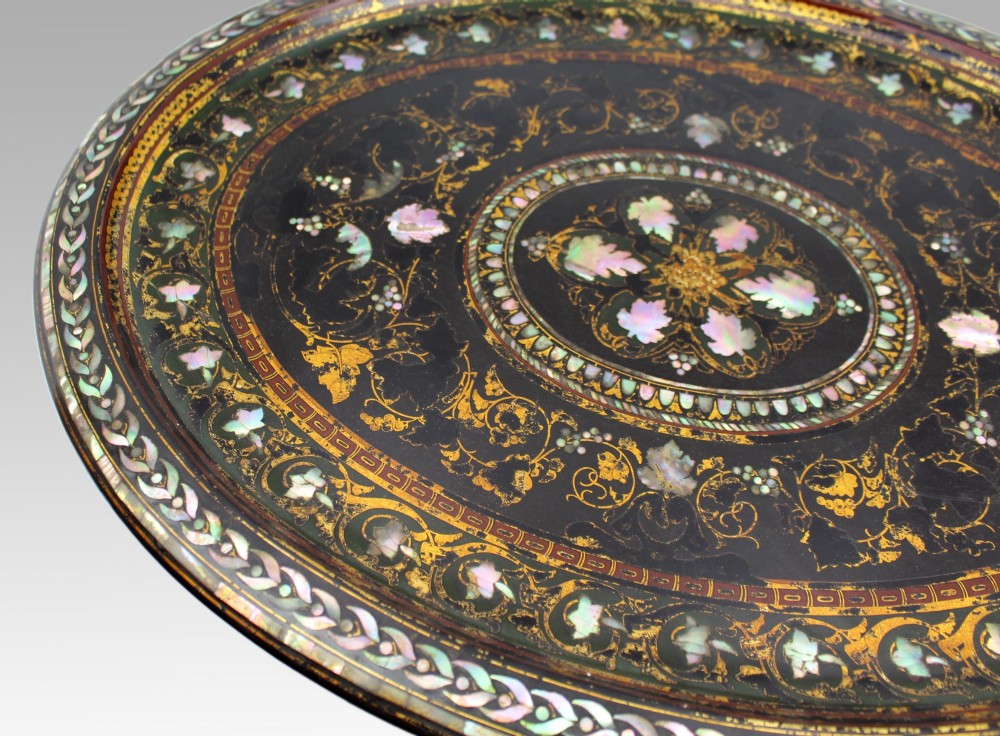 An oval Victorian black lacquered papier-mache tray featuring ornate gilt floral scrolls and iridescent mother-of-pearl leaf inlays around a central medallion. View IX