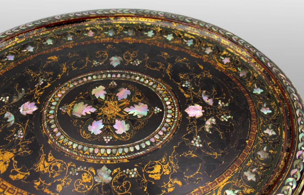 An oval Victorian black lacquered papier-mache tray featuring ornate gilt floral scrolls and iridescent mother-of-pearl leaf inlays around a central medallion. View X