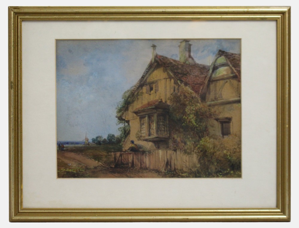 A framed watercolour painting depicting a timber-framed English rural cottage under a soft blue sky set in a gilt frame with a white mount.