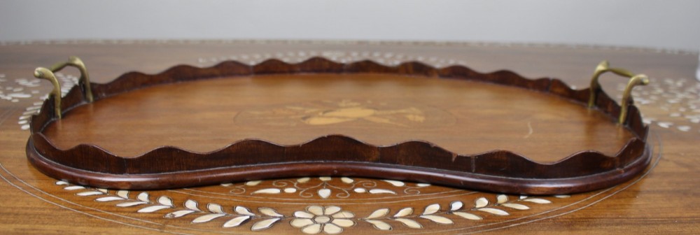 A kidney-shaped mahogany serving tray with central marquetry inlay, a scalloped gallery rim, and two brass handles. View II