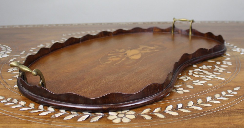 A kidney-shaped mahogany serving tray with central marquetry inlay, a scalloped gallery rim, and two brass handles. View III
