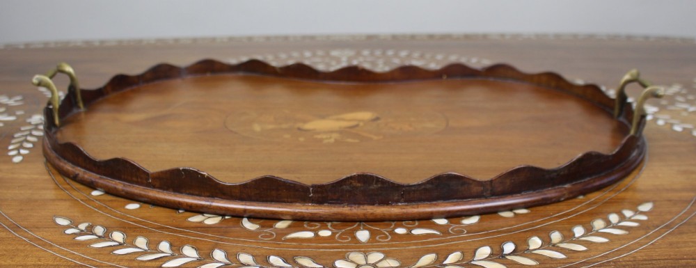 A kidney-shaped mahogany serving tray with central marquetry inlay, a scalloped gallery rim, and two brass handles. View IV