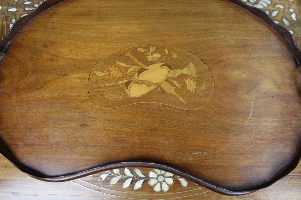 A kidney-shaped mahogany serving tray with central marquetry inlay, a scalloped gallery rim, and two brass handles. View VII