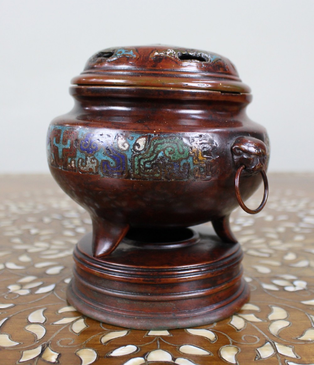 An antique Chinese bronze tripod censer featuring a band of turquoise and blue cloisonne enamel work, mask handles with loose rings, and a pierced lid. View III