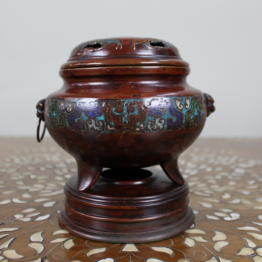 An antique Chinese bronze tripod censer featuring a band of turquoise and blue cloisonne enamel work, mask handles with loose rings, and a pierced lid. View IV