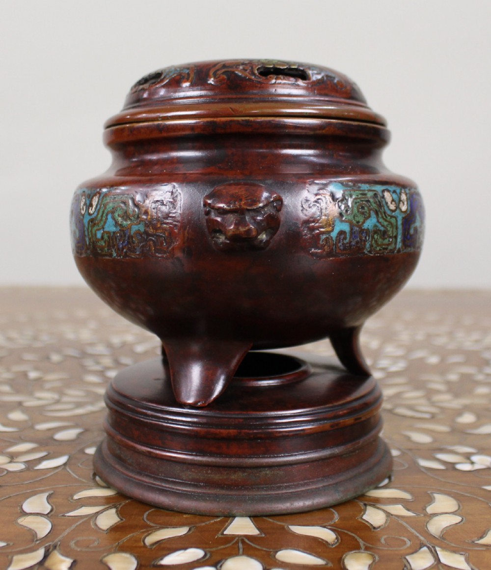 An antique Chinese bronze tripod censer featuring a band of turquoise and blue cloisonne enamel work, mask handles with loose rings, and a pierced lid. View V