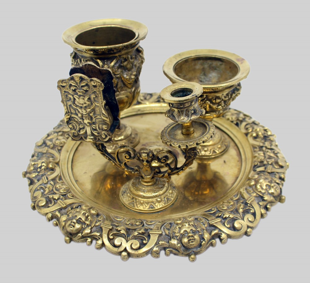 A 19th-century cast brass writing desk set featuring an ornate rimmed tray, two urn-shaped pots, and a small chamberstick. View VI