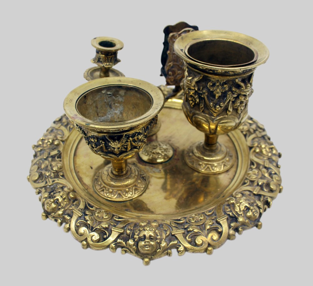 A 19th-century cast brass writing desk set featuring an ornate rimmed tray, two urn-shaped pots, and a small chamberstick. View VII