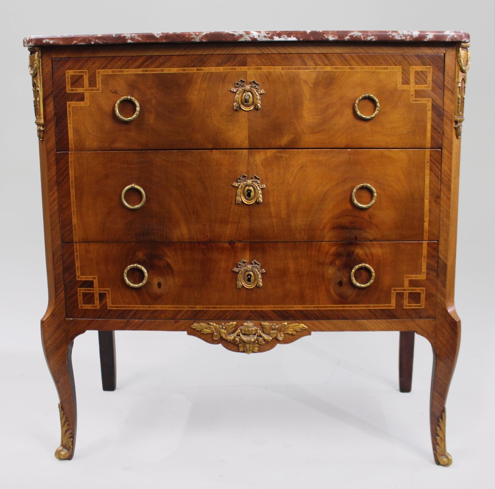 A French Louis XVI style mahogany and tulipwood three-drawer commode featuring geometric inlay, ormolu mounts, and a red mottled marble top. View III
