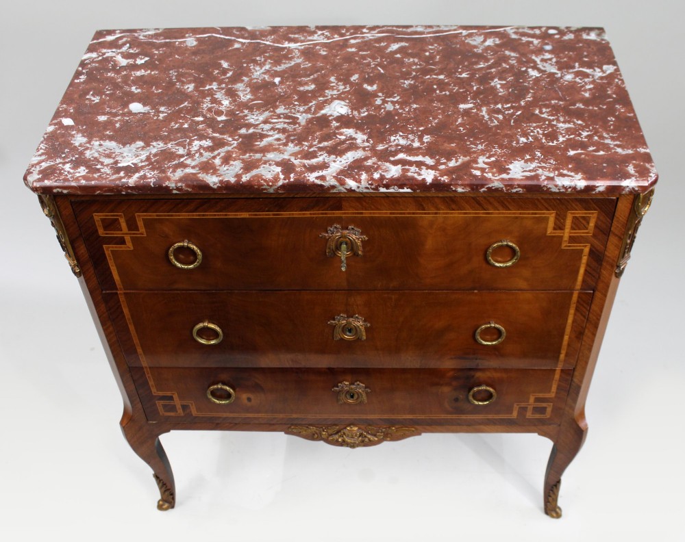 A French Louis XVI style mahogany and tulipwood three-drawer commode featuring geometric inlay, ormolu mounts, and a red mottled marble top. View V