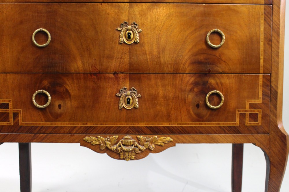 A French Louis XVI style mahogany and tulipwood three-drawer commode featuring geometric inlay, ormolu mounts, and a red mottled marble top. View VIII