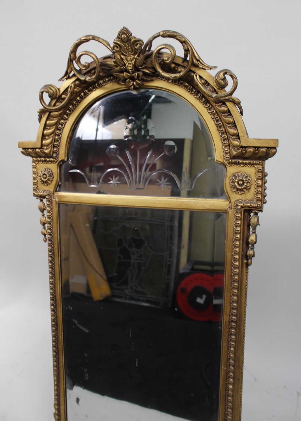 A Regency giltwood pier mirror with ornate cresting, beaded frame details, and an upper arched mirror section featuring intaglio cut floral designs. View II