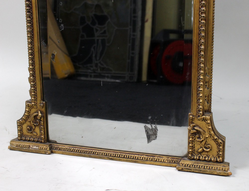 A Regency giltwood pier mirror with ornate cresting, beaded frame details, and an upper arched mirror section featuring intaglio cut floral designs. View VI