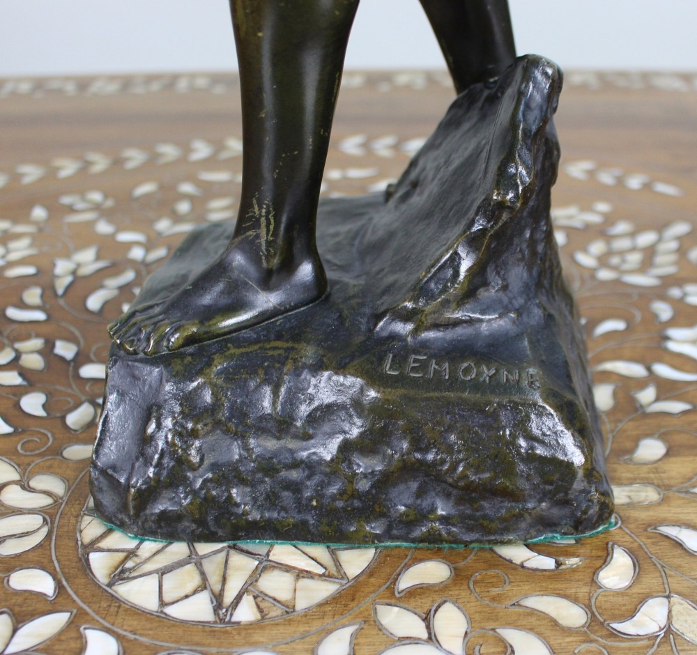 A dark brown patinated bronze figure of a classical male standing on a rocky base, holding a chalice in one hand and raising a laurel wreath aloft in the other. View V
