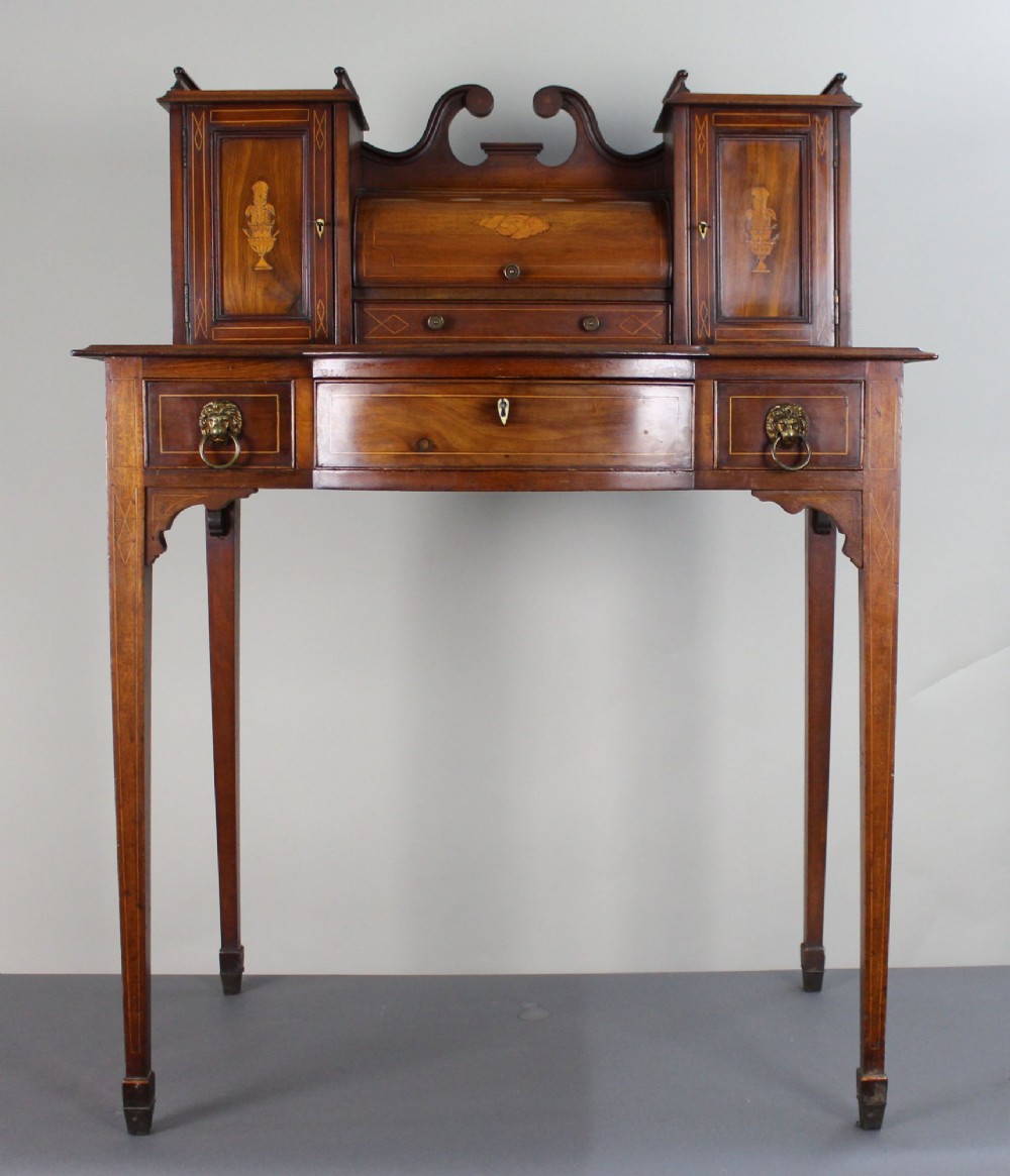 An Edwardian inlaid mahogany writing desk with a central drawer, satinwood urn marquetry, twin side cabinets, and tapered legs. View III