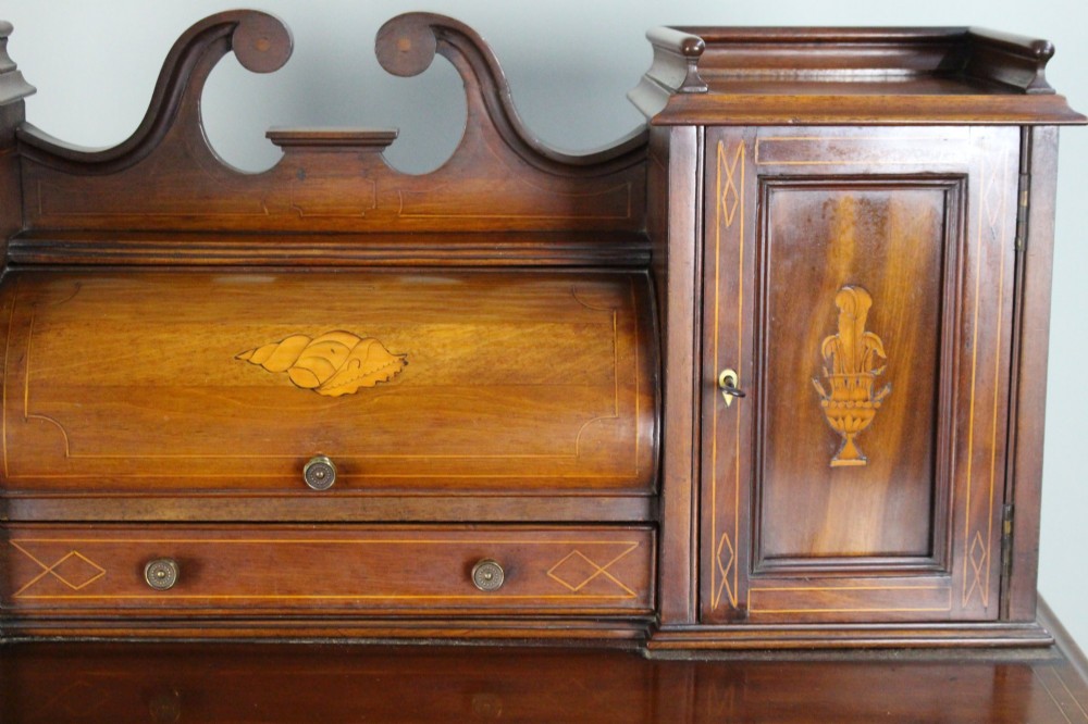 An Edwardian inlaid mahogany writing desk with a central drawer, satinwood urn marquetry, twin side cabinets, and tapered legs. View VIII