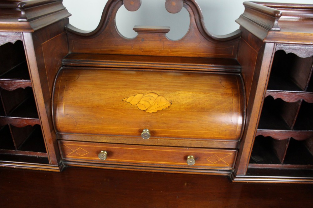 An Edwardian inlaid mahogany writing desk with a central drawer, satinwood urn marquetry, twin side cabinets, and tapered legs. View IX
