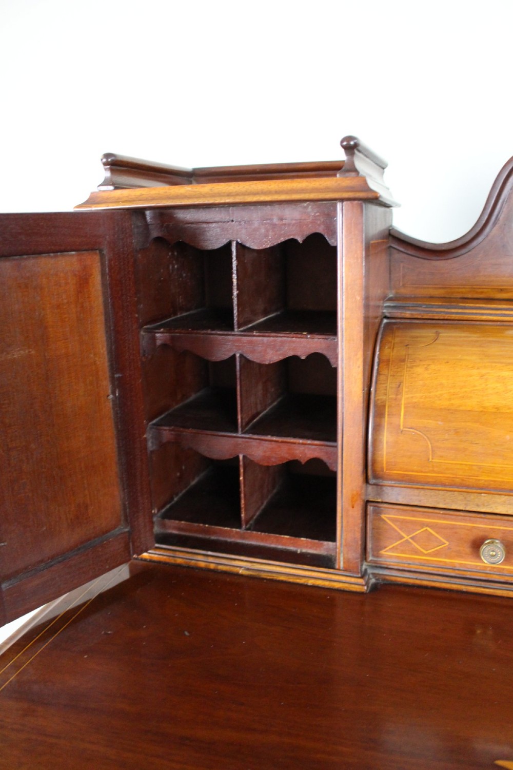 An Edwardian inlaid mahogany writing desk with a central drawer, satinwood urn marquetry, twin side cabinets, and tapered legs. View X