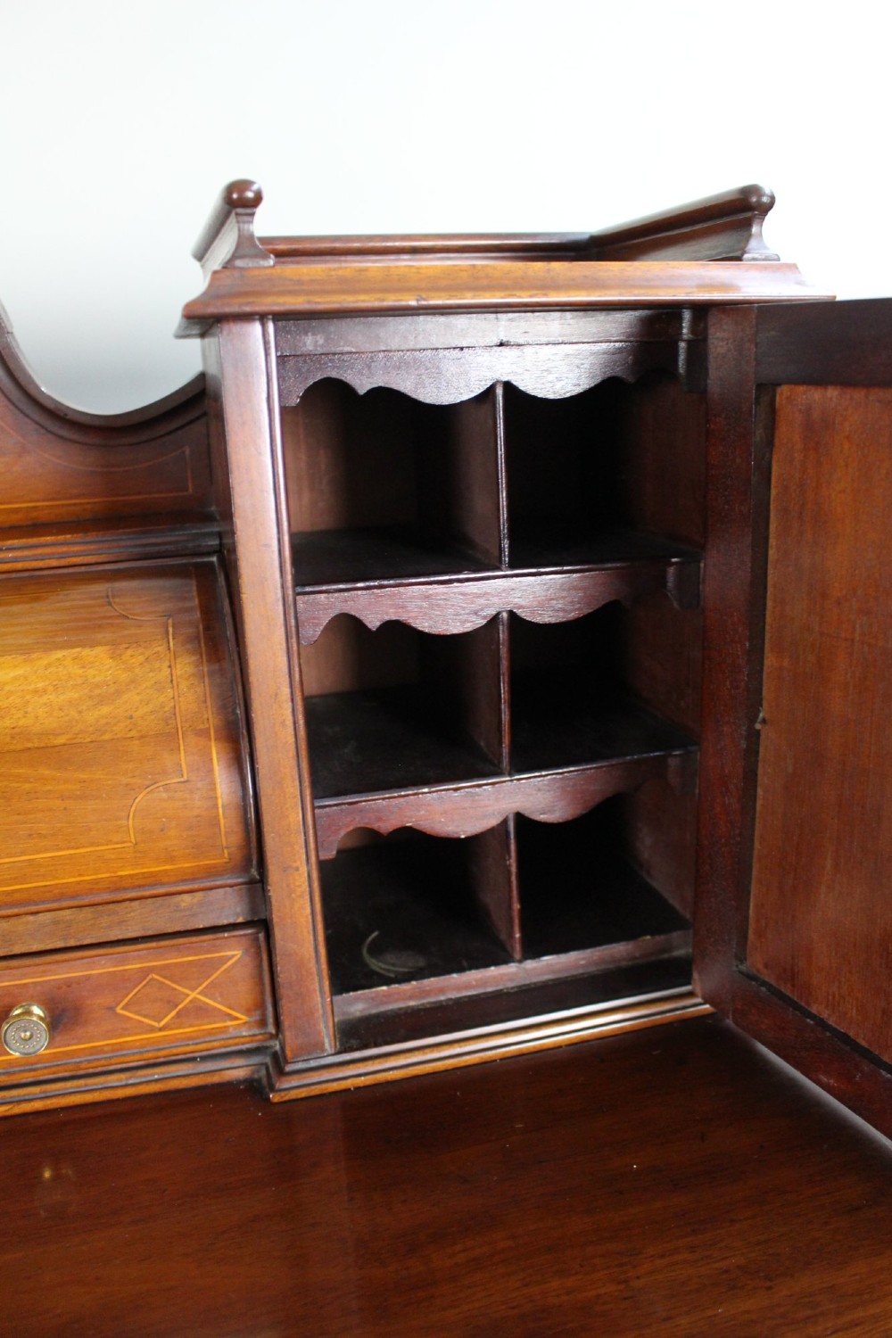 An Edwardian inlaid mahogany writing desk with a central drawer, satinwood urn marquetry, twin side cabinets, and tapered legs. View XII
