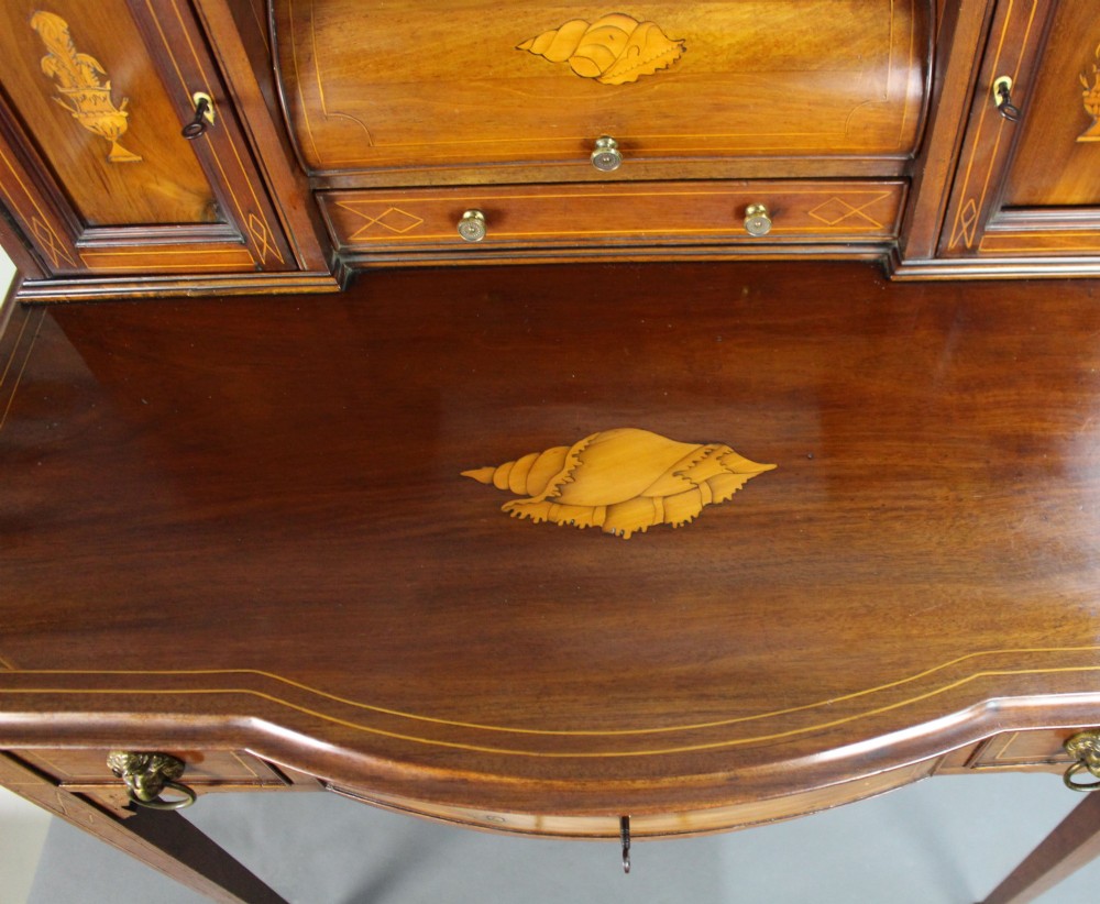 An Edwardian inlaid mahogany writing desk with a central drawer, satinwood urn marquetry, twin side cabinets, and tapered legs. View XIII