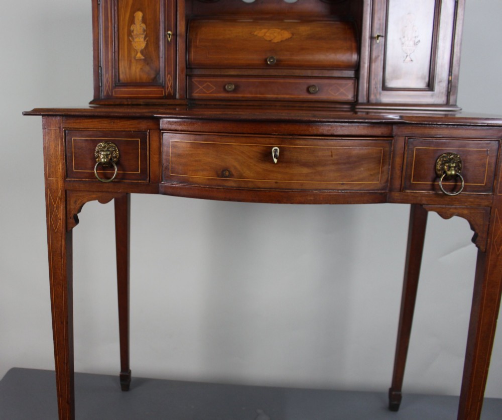 An Edwardian inlaid mahogany writing desk with a central drawer, satinwood urn marquetry, twin side cabinets, and tapered legs. View XIV