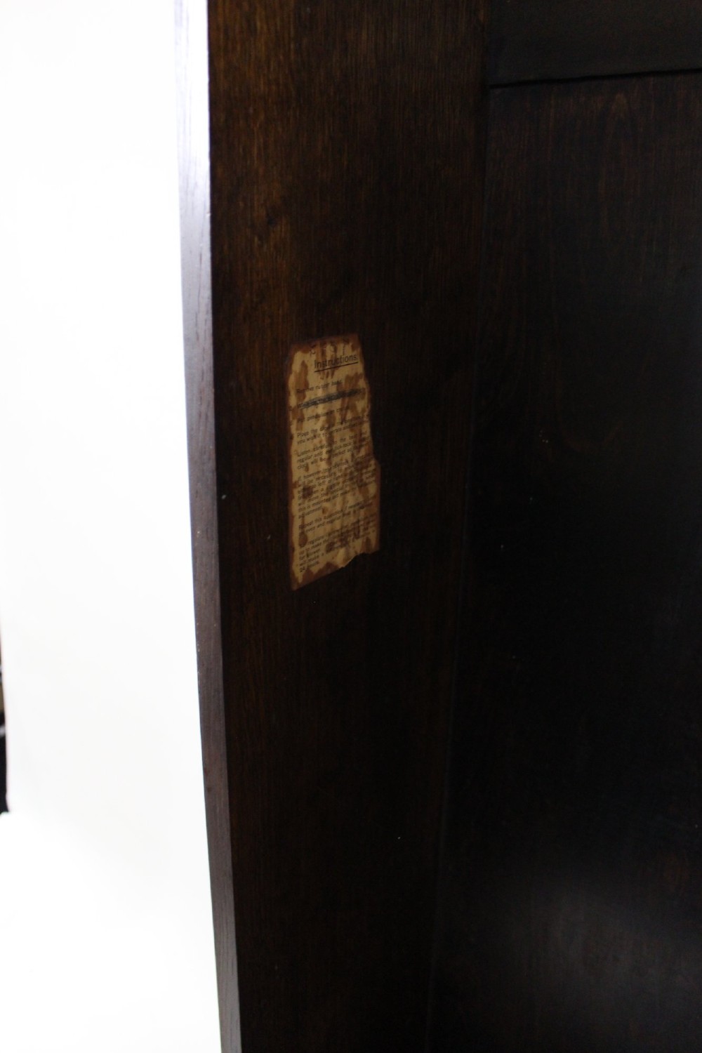 An Art Deco dark oak longcase clock case featuring a domed hood and glazed door alongside an unmounted brass movement, pendulum, chrome dial, and three cylindrical weights. View X